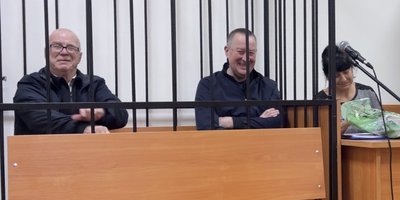 During the trial, Yuriy Sergeechev and Aleksey Dmitriyev were kept in a cage. To the right of Aleksey is his wife Svetlana. December 2025